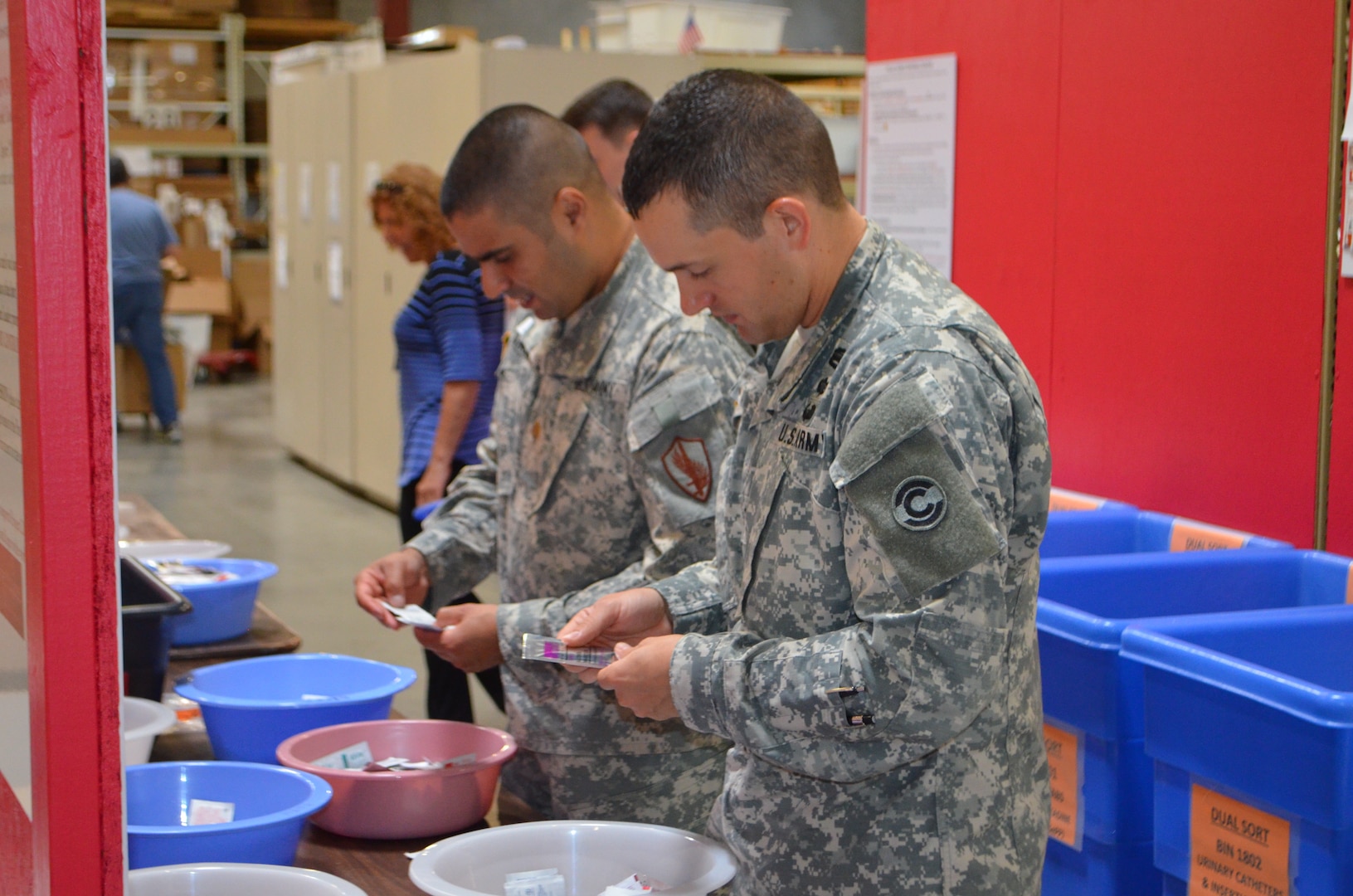 Maj. Ashkan Angha and Capt. Derek Richter sort various donated medical supplies at Project CURE’s International Headquarters in Centennial, Colorado, June 26, 2015  The 50,000 square foot warehouse stores donated medical supplies and equipment until transported to a country in need.  Recently Project CURE, with the help of the Colorado National Guard’s State Partnership Program, donated a 20 foot shipping container full of medical supplies and equipment to the Hashemite Kingdom of Jordan in support of the Syrian and Iraqi refugees. (Photo by U.S. Air Force Lt. Col. Nicole David/Released)