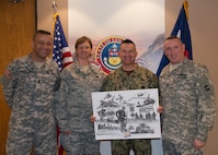 Command Sgt. Maj. Russell Hamilton, Chief Master Sgt. Annadele Kenderes, Fleet Master Chief Terrence I. Molidor, Command Sgt. Maj. Michael Lawrence, stand during a presentation of a print to Molidor on his introductory meeting with senior leaders of the Colorado National Guard in Centennial, Colorado Feb. 6, 2015. (U.S. Air Force photo by Tech. Sgt. Jecca Geffre/Released)