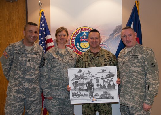 Command Sgt. Maj. Russell Hamilton, Chief Master Sgt. Annadele Kenderes, Fleet Master Chief Terrence I. Molidor, Command Sgt. Maj. Michael Lawrence, stand during a presentation of a print to Molidor on his introductory meeting with senior leaders of the Colorado National Guard in Centennial, Colorado Feb. 6, 2015. (U.S. Air Force photo by Tech. Sgt. Jecca Geffre/Released)