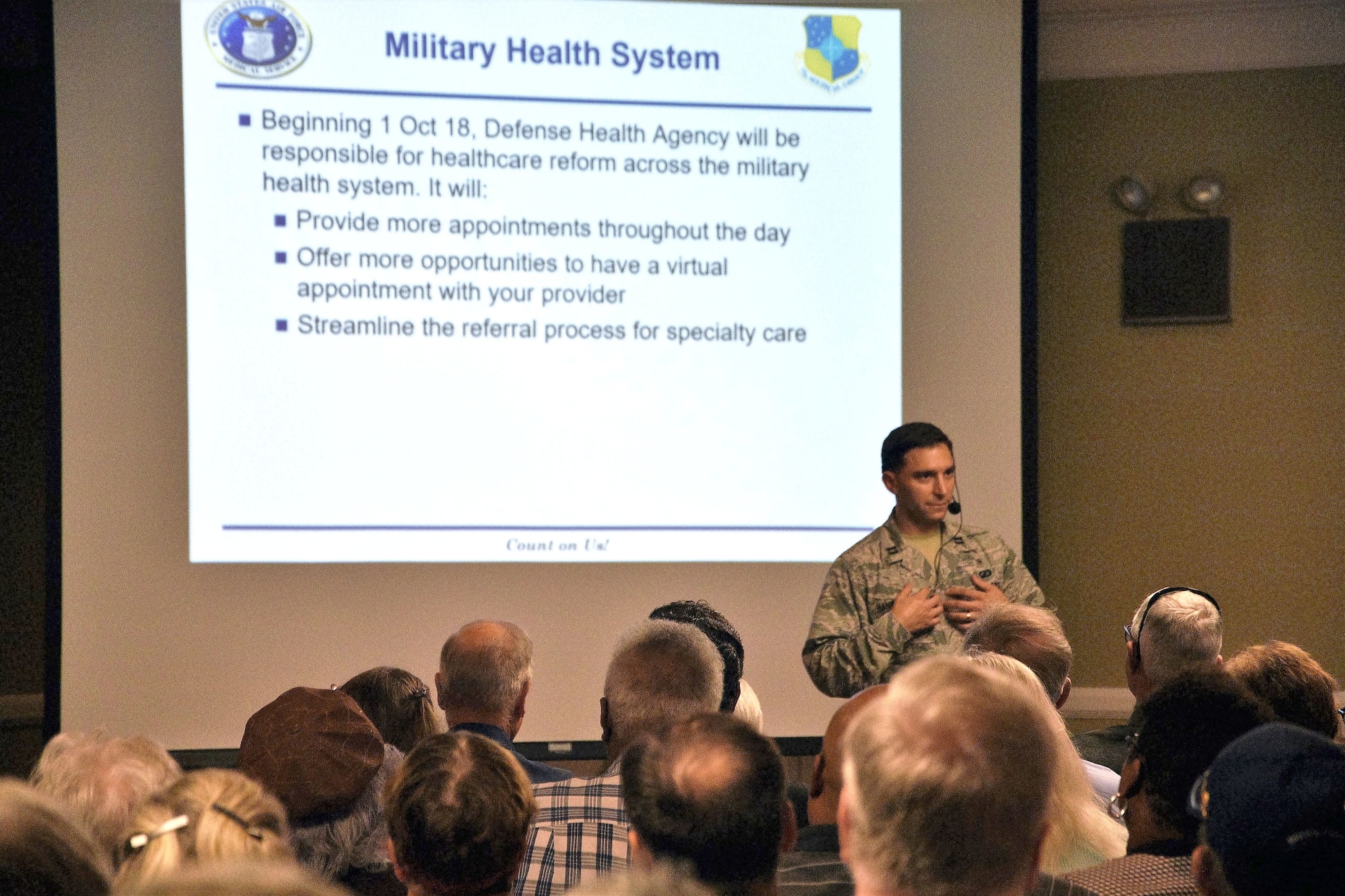 Capt. Saxon Hanwacker addresses more than 200 people who attended the TRICARE town hall. Hanwacker introduced a limited time offer where dependents and retirees can have Primary Care Managers off base. (U.S. Air Force photo/2nd Lt. Ashlyn K. Paulson)