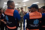 A U.S. Navy Sailor demonstrates proper tourniquet techniques with a Honduran emergency response medical professional.