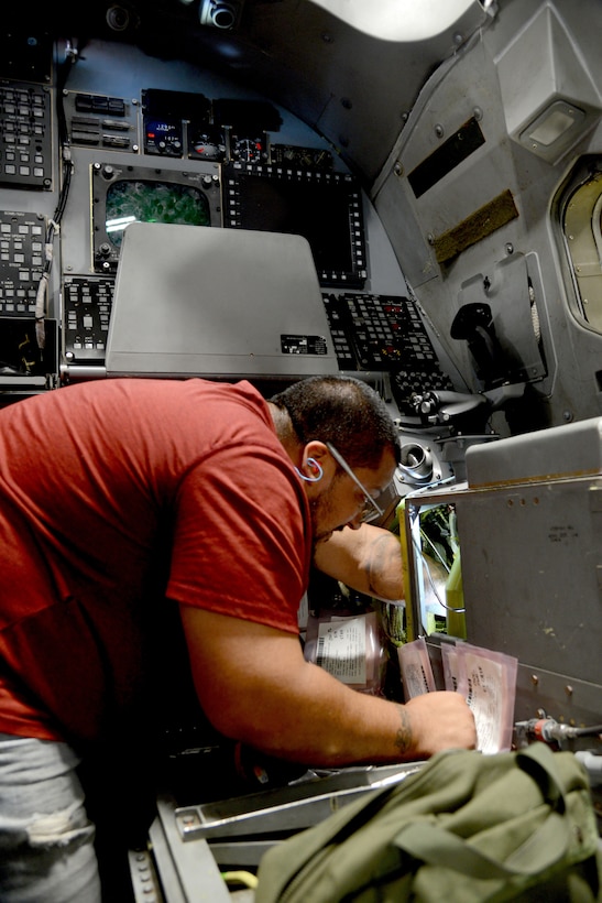 Ernesto Pena, an aircraft ordnance mechanic, works on the offensive system operator section of a B-1B Lancer.