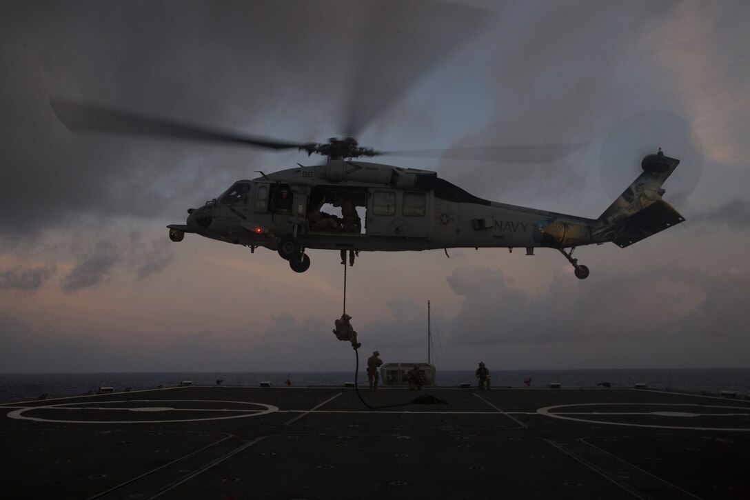 U.S. Navy sailors repel from a MH-60S Knighthawk with Helicopter Sea Combat Squadron 25 aboard the SS Curtiss during a helicopter boarding search and seizures simulation Sept. 18, 2018, during Valiant Shield. Valiant Shield is a biennial, U.S.-only field training exercise (FTX) with a focus on integration of joint training among U.S. forces in relation to current operational plans. This training enables real-world proficiency in sustaining joint forces through detecting, location, tracking, and engaging units at sea, in the air, on land, and cyberspace in response to a range of mission areas. (U.S. Marine Corps photo by Lance Cpl. Kenny Nunez)