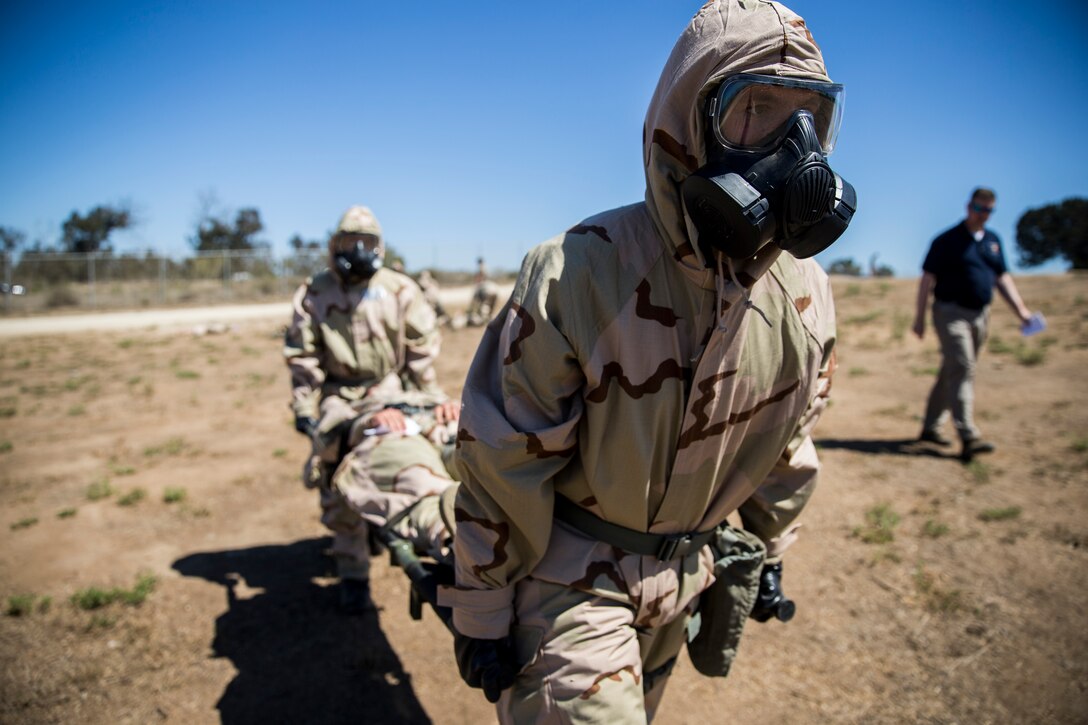 U.S. Marine Corps Base Camp Pendleton, CA – Marines with 3rd Battalion, 5th Marine Regiment, 1st Marine Division, carry a simulated casualty of a chemical agent attack to the decontamination front line on Camp Pendleton, Calif., Sept. 14, 2018. One of the first things the Marines must do is move the casualties from the area of the attack because of lingering agents or the possibility of another attack. (U.S. Marine Corps photo by Cpl. Adam Dublinske)