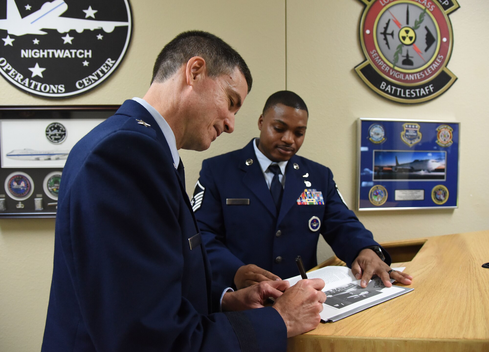 U.S. Air Force Brig. Gen. Paul W. Tibbets IV, Air Force Global Strike Command deputy commander, Barksdale Air Force Base, Louisiana, signs a book for Master Sgt. Sherman Roberts, 334th Training Squadron instructor, during a room dedication ceremony at Cody Hall on Keesler Air Force Base, Mississippi, Sept. 14, 2018. The dedication honored Tibbets' grandfather, retired Brig. Gen. Paul W. Tibbets Jr., by dedicating the 334th Training Squadron Command and Control simulator in his name. Tibbets Jr., piloted the Enola Gay, which dropped the world's first atomic bomb. (U.S. Air Force photo by Kemberly Groue)