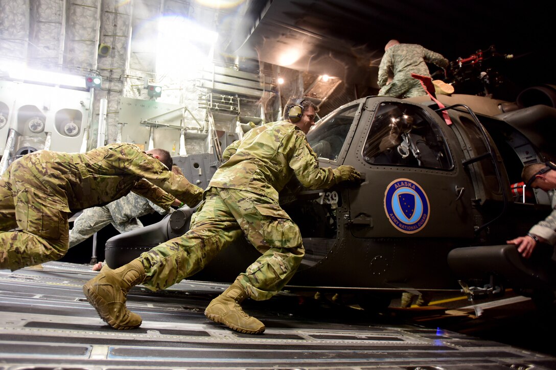 Soldiers offload a UH-60 Black Hawk helicopter.