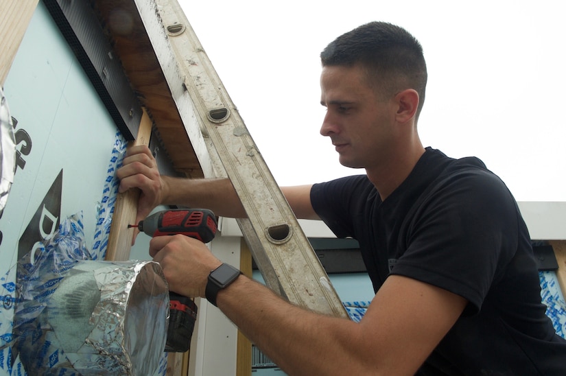 Air Force Senior Airman Daniel Eury Jr. drills a screw into a home he’s helping to build with Habitat for Humanity in Washington, D.C.