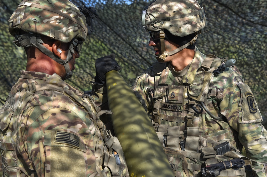 A soldier checks a 155 mm round for a M777 howitzer during a live-fire exercise.