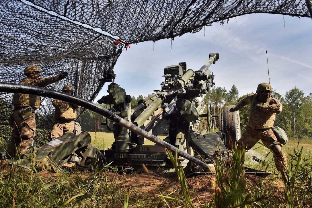 A soldier prepares to pull the firing lanyard on a M777 howitzer during a live-fire exercise.