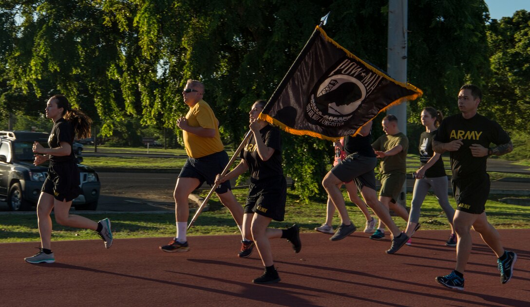 Members from the Defense POW/MIA Accounting Agency kick off the 24-hour run for Prisoners of War and Missing in Action Week, Joint Base Pearl Harbor-Hickam, Hawaii, Sept. 20, 2018.  There were seven military service men from Hawaii who were prisoners of war, missing in action, or whose bodies were never recovered. From Sept. 17-21, events will be held throughout JBPHH as part of POW/MIA Recognition Week. The events include readings of the POW/MIA names, a reveille ceremony, beautification of POW/MIA memorial, information tables, sentinel posting, a 24-hour run, and ends on Friday with a POW/MIA Remembrance Ceremony at the National Memorial Cemetery of the Pacific in Honolulu. Observances of National POW/MIA Recognition Day are held across the country on military installations, ships at sea, state capitals, schools and veterans facilities. It is traditionally observed on the third Friday in September each year. (U.S. Air Force photo by Tech. Sgt. Heather Redman)