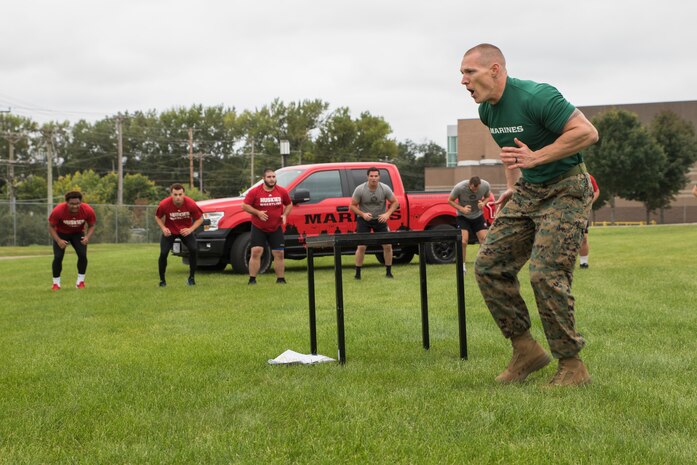 ST. CLOUD, Minn. -- The Marine Corps Officer Selection Team from Fargo, North Dakota, pushes the St. Cloud State University Wrestling team through a Leadership and Cohesion Exercise designed to test their physical and mental strength, as well as their ability to work as team, in St. Cloud, M.N., Sept. 18, 2018. At the end of the exercises, the Marines lead the team through a discussion about their core values; honor, courage and commitment, and how the athletes can apply those values to what they do as wrestlers, but also as students and ambassadors for the university.