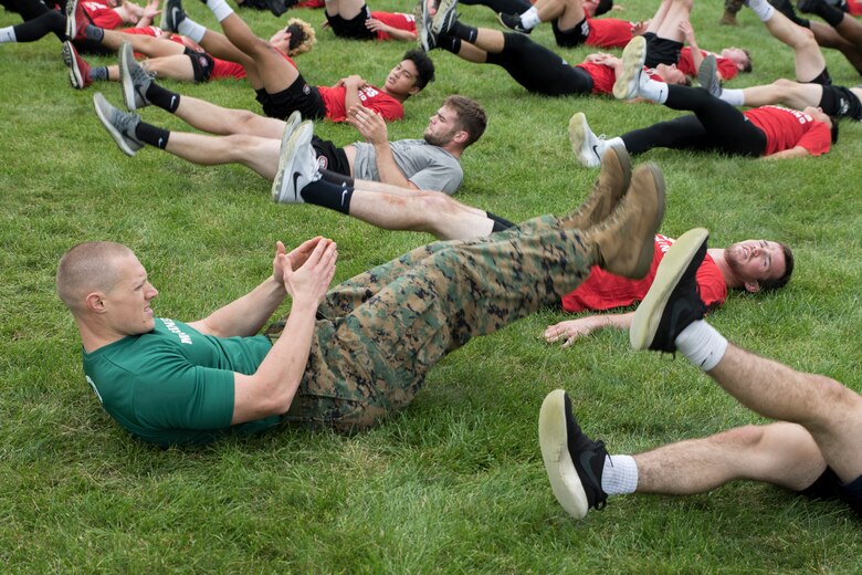 ST. CLOUD, Minn. -- The Marine Corps Officer Selection Team from Fargo, North Dakota, pushes the St. Cloud State University Wrestling team through a Leadership and Cohesion Exercise designed to test their physical and mental strength, as well as their ability to work as team, in St. Cloud, M.N., Sept. 18, 2018. At the end of the exercises, the Marines lead the team through a discussion about their core values; honor, courage and commitment, and how the athletes can apply those values to what they do as wrestlers, but also as students and ambassadors for the university.