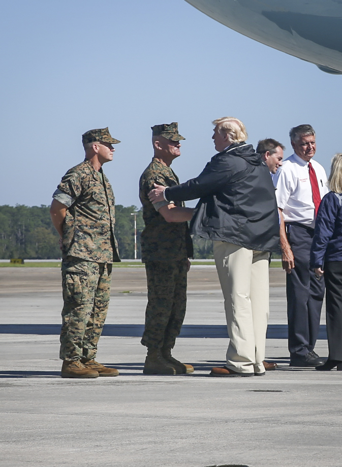 President Donald J. Trump greets Brig. Gen. Karsten Heckl after stepping off Air Force One at Marine Corps Air Station Cherry Point, N.C., Sept. 19, 2018. Heckl and Col. Todd Ferry, left, Cherry Point’s commanding officer, were part of the reception committee for Trump’s visit to Eastern North Carolina.  Trump met with local and state officials, senior military leaders, and disaster relief agency representatives in a large hangar on the Cherry Point flight line to discuss damage, post-hurricane conditions, and how the country would work to get Carolinians back on their feet. After the roundtable discussion, the president toured damaged areas of Craven County, distributing goods from a church in New Bern, N.C., to community members effected by the destructive storm. Heckl is the 2nd Marine Aircraft Wing commanding general. (Marine Corps photo by Cpl. Micha Pierce)