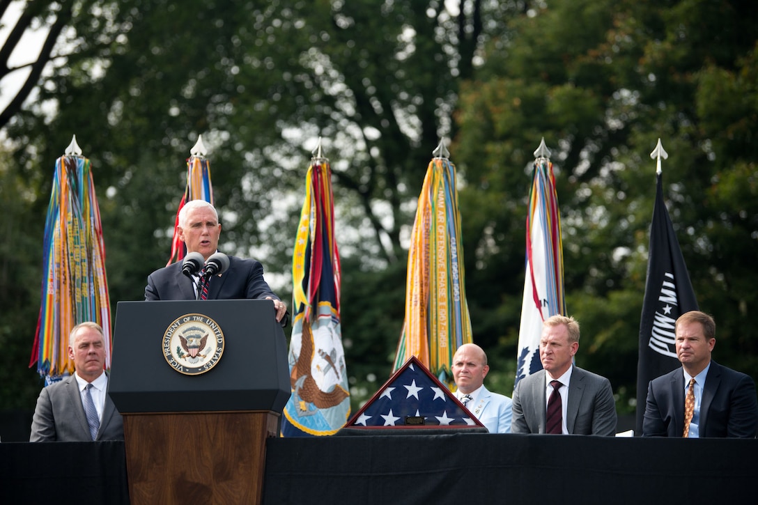 Vice President Mike Pence speaks at a lectern as Deputy Defense Secretary Patrick M. Shanahan looks on while seated on stage.