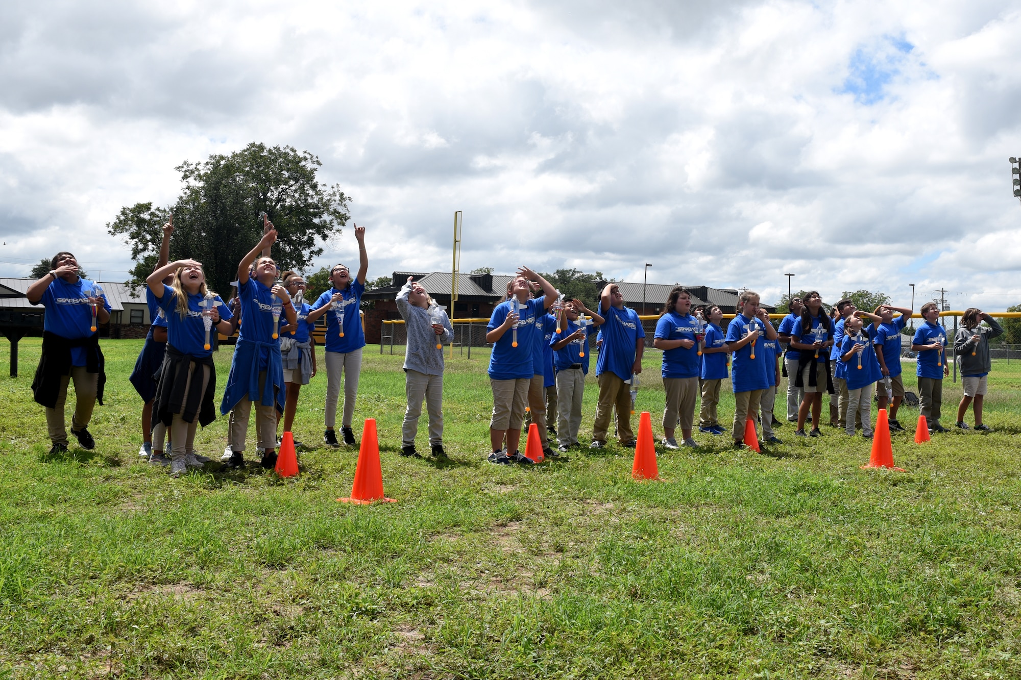 Students attending STARBASE Goodfellow watch as their water-bottle rockets fall after being launched at Goodfellow Air Force Base, Texas, Sept. 12, 2018. The children learned about Newton’s Laws and used the rockets as a hands-on demonstration of the concepts. (U.S. Air Force photo by Airman 1st Class Zachary Chapman/Released)
