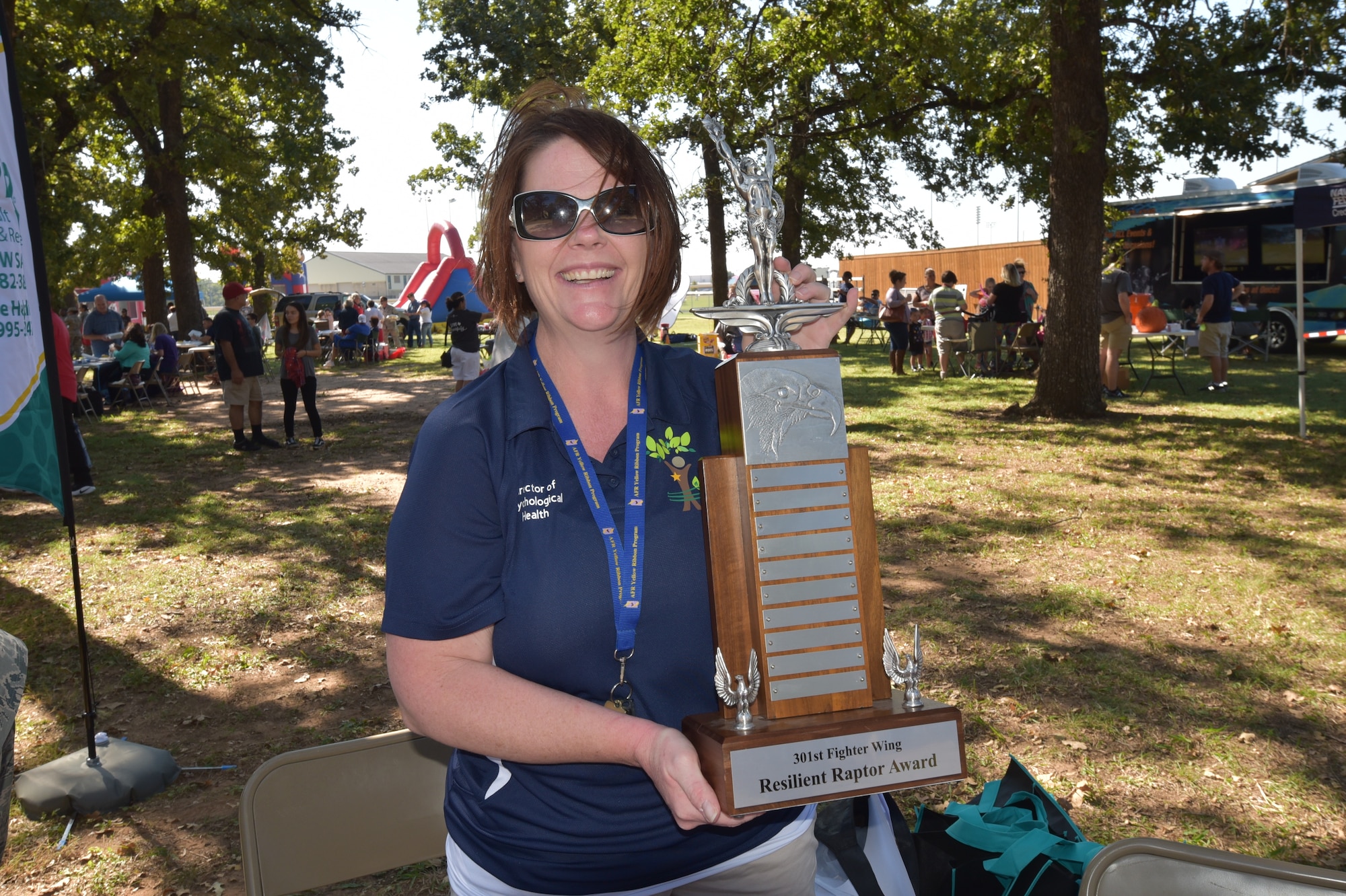 Ms. Mary Arnold, 301st Director of Psychological Health (DPH), shows off the winner's trophy for the Amazing Race at Family Day, Oct. 14, 2017. Eleven teams from across the 301st Fighter Wing participated in the race while learning resiliency techniques.