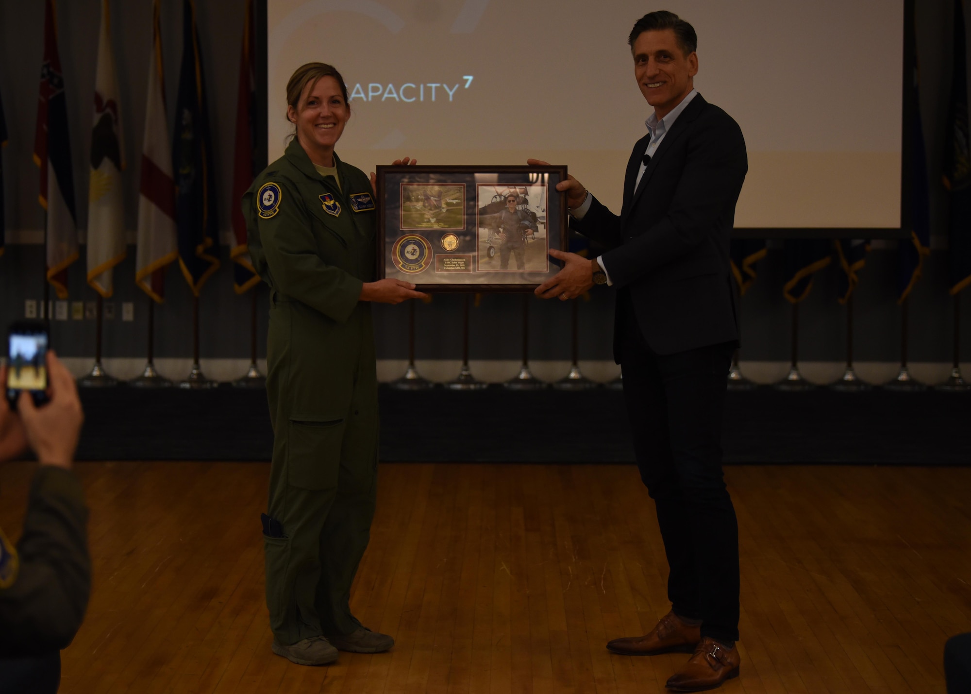 Col. Samantha Weeks, 14th Flying Training Wing commander, hands a gift to Andy Christiansen, motivational speaker, Sept. 14, 2018, on Columbus Air Force Base, Mississippi. Christiansen spoke to hundreds of Airmen here during lectures and small group discussions Sept. 12-14 to give new perspectives on leadership and mentorship. (U.S. Air Force photo by Airman 1st Class Keith Holcomb)