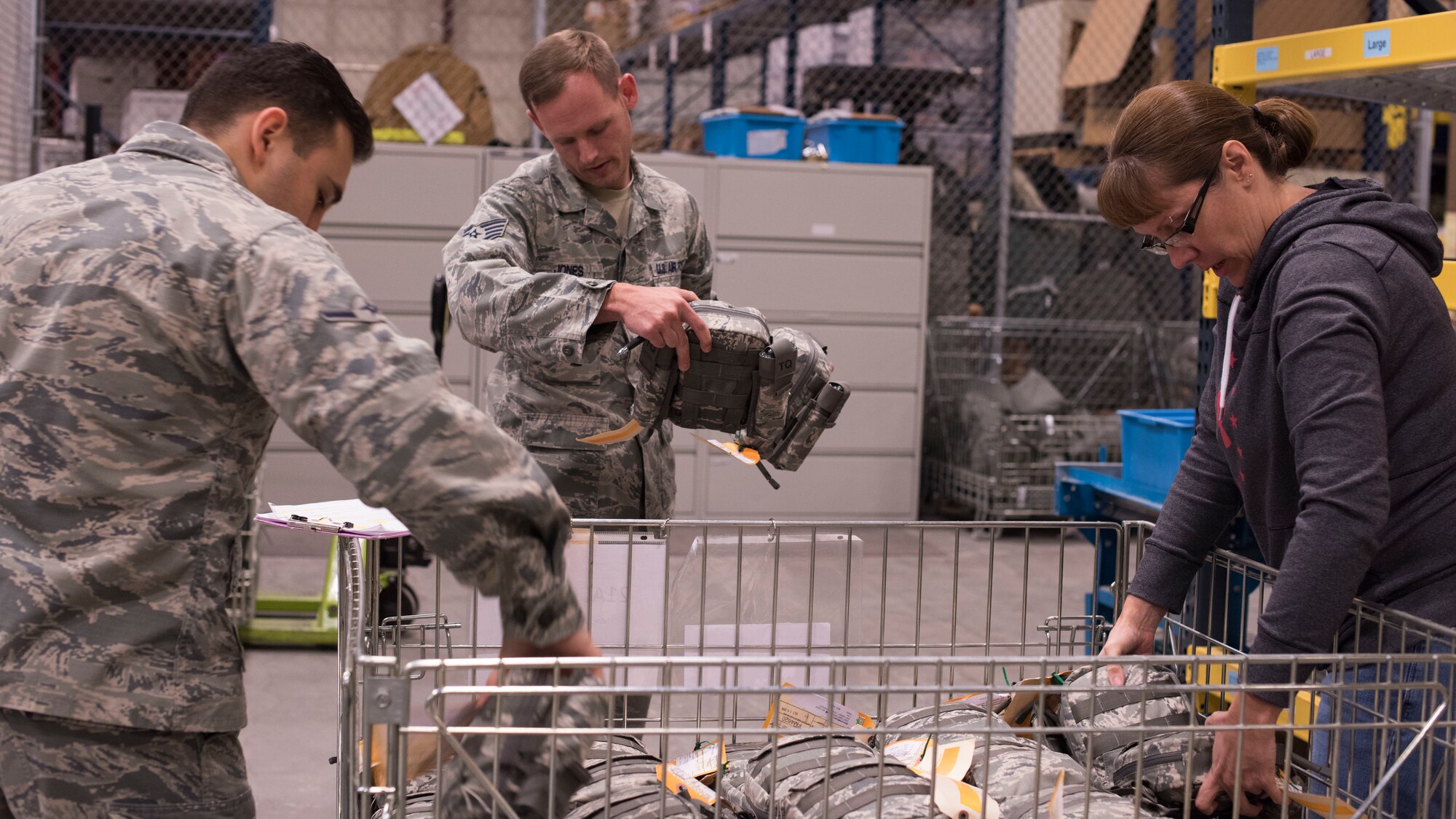 Airman Diego Najera-Dominguez, 92nd Logistics Readiness Squadron Individual Protective Equipment apprentice (left), Staff Sgt. Jeffery Jones, 92nd LRS Individual Protective Equipment supervisor, and Jessica Parker, 92nd LRS IPE Supply Technician supervisor, sort through Joint First Aid Kit packages Sept. 19, 2018, at Fairchild Air Force Base, Washington. Logistics Airmen are tasked with the organization, tracking and issuing of hundreds of thousands of individual pieces of gear for training and deployment purposes. (U.S. Air Force photo/Senior Airman Ryan Lackey)