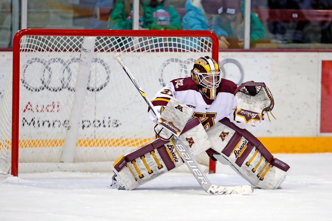 An airman plays goalie in front of a net.