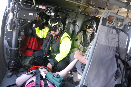 Flood victims hold hands aboard a UH-60 Black Hawk helicopter during an aerial evacuation over Marion County, South Carolina, Sept. 20, 2018. Pennsylvania Guard air crews joined to rescue them.