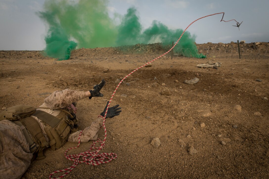 DJIBOUTI (Sept. 17, 2018) Lance Cpl. Quenton Timmerman, an assault Marine assigned to Kilo Company, Battalion Landing Team 3/1, 13th Marine Expeditionary Unit, throws a hook during an obstacle clearing drill during Theater Amphibious Combat Rehearsal (TACR) 18. Led by Naval Amphibious Force, Task Force 51/5th Marine Expeditionary Brigade, TACR integrates U.S. Navy and Marine Corps assets to practice and rehearse a range of critical combat-related capabilities available to U.S. Central Command, both afloat and ashore, to promote stability and security in the region. U.S. 5th Fleet and coalition assets are participating in numerous simultaneous exercises as part of the greater Theater Counter Mine and Maritime Security Exercise to ensure maritime stability and security in the U.S. Central Command area of responsibility, connecting the Mediterranean and the Pacific through the western Indian Ocean and three strategic choke points. (U.S. Marine Corps photo by Cpl. Danny Gonzalez/Released)