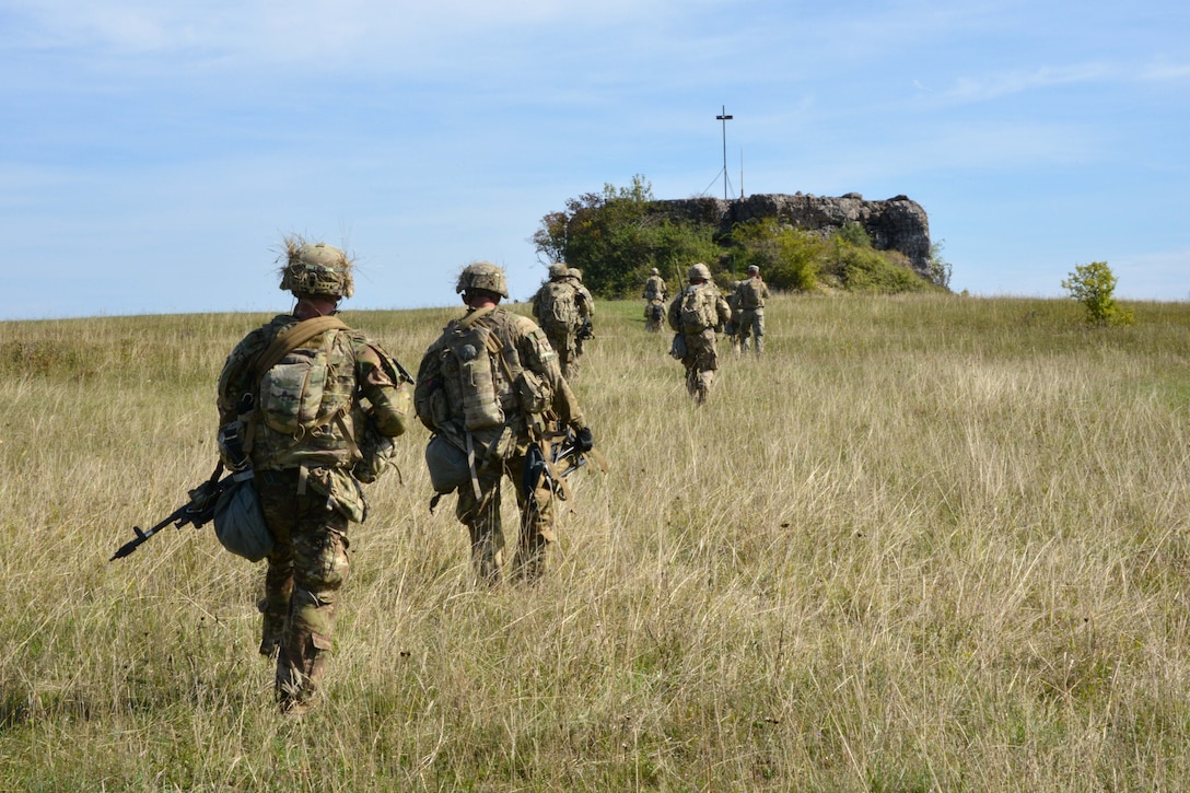 Soldiers maneuver through a field toward their follow-on objective during air assault training.