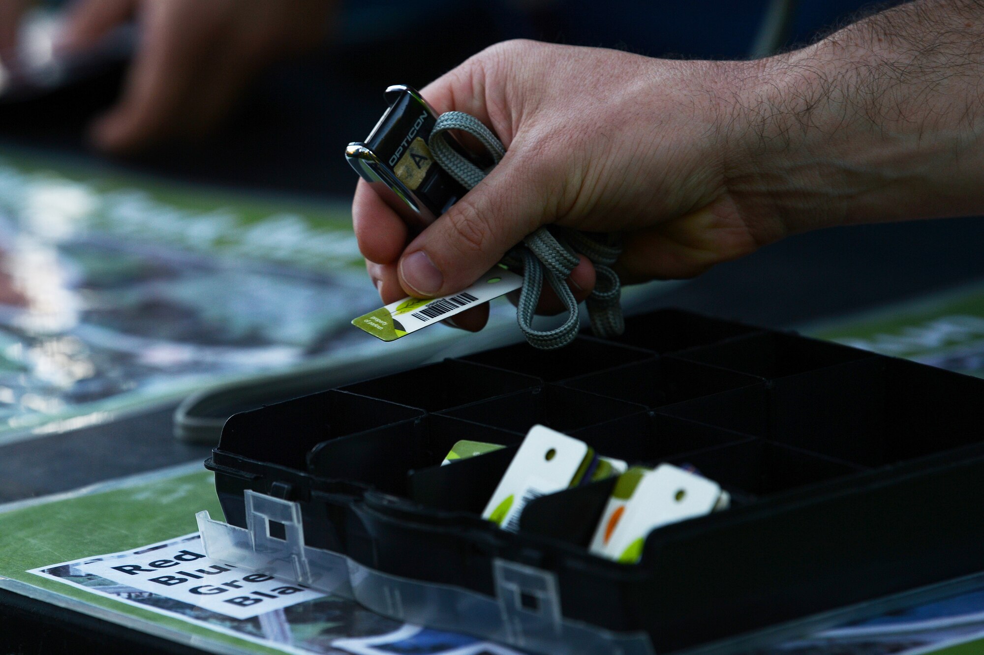 An Airman assigned to Detachment 16, 372nd Training Squadron, places a barcode token into its container at the Thetford Parkrun in Thetford, England, Sept. 15, 2018. Runners must register and bring their barcodes in order to log their times. (U.S. Air Force photo/Airman 1st Class Shanice Williams-Jones)