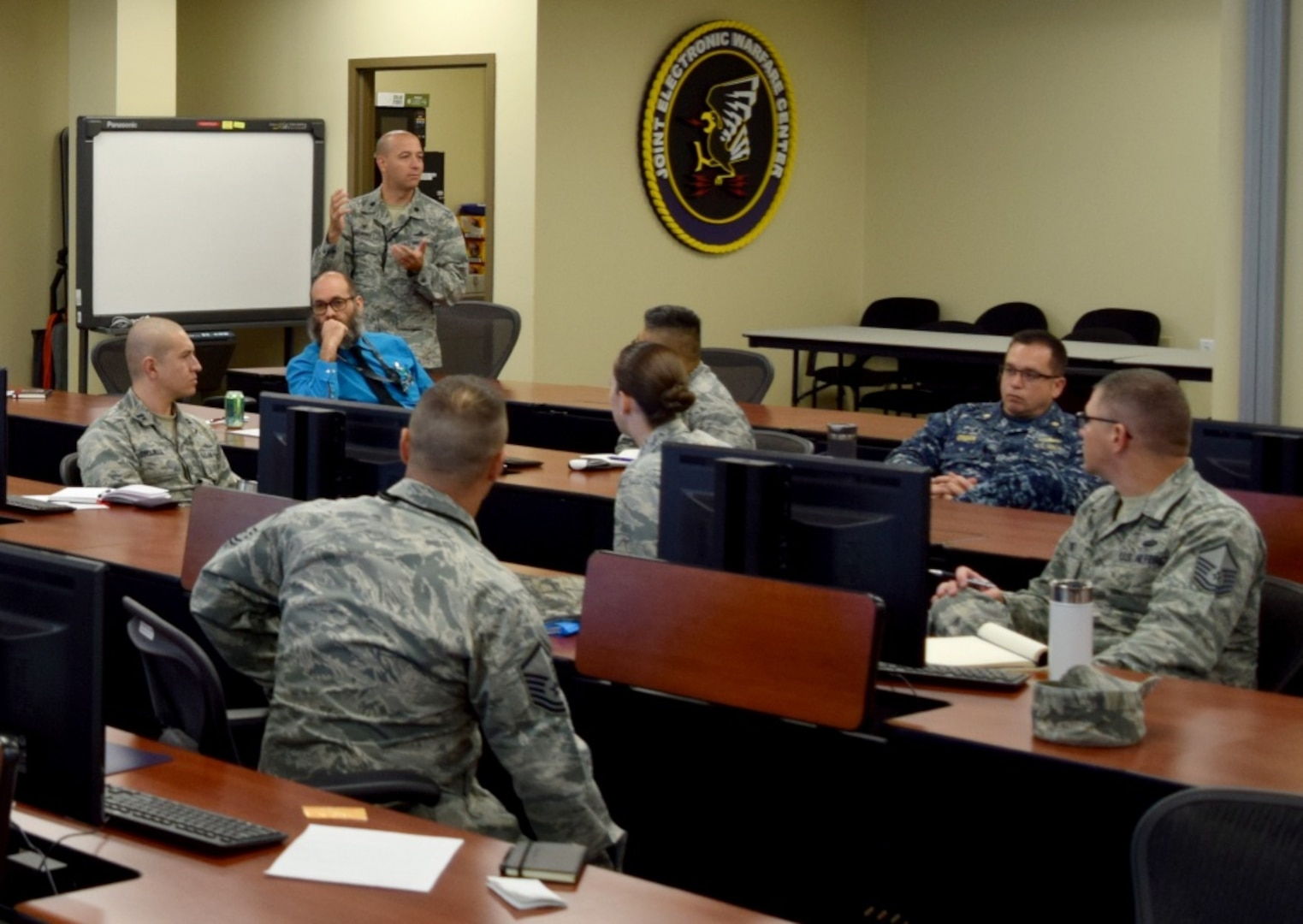 Military cyber experts meet in a conference room.