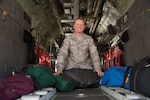 Senior Master Sgt. William Kellums, the 302nd Operations Support Squadron aircrew flight equipment superintendent, sits aboard a parked C-130 Hercules aircraft with custom-made equipment bags at Peterson Air Force Base, Colorado, Aug. 15, 2018.