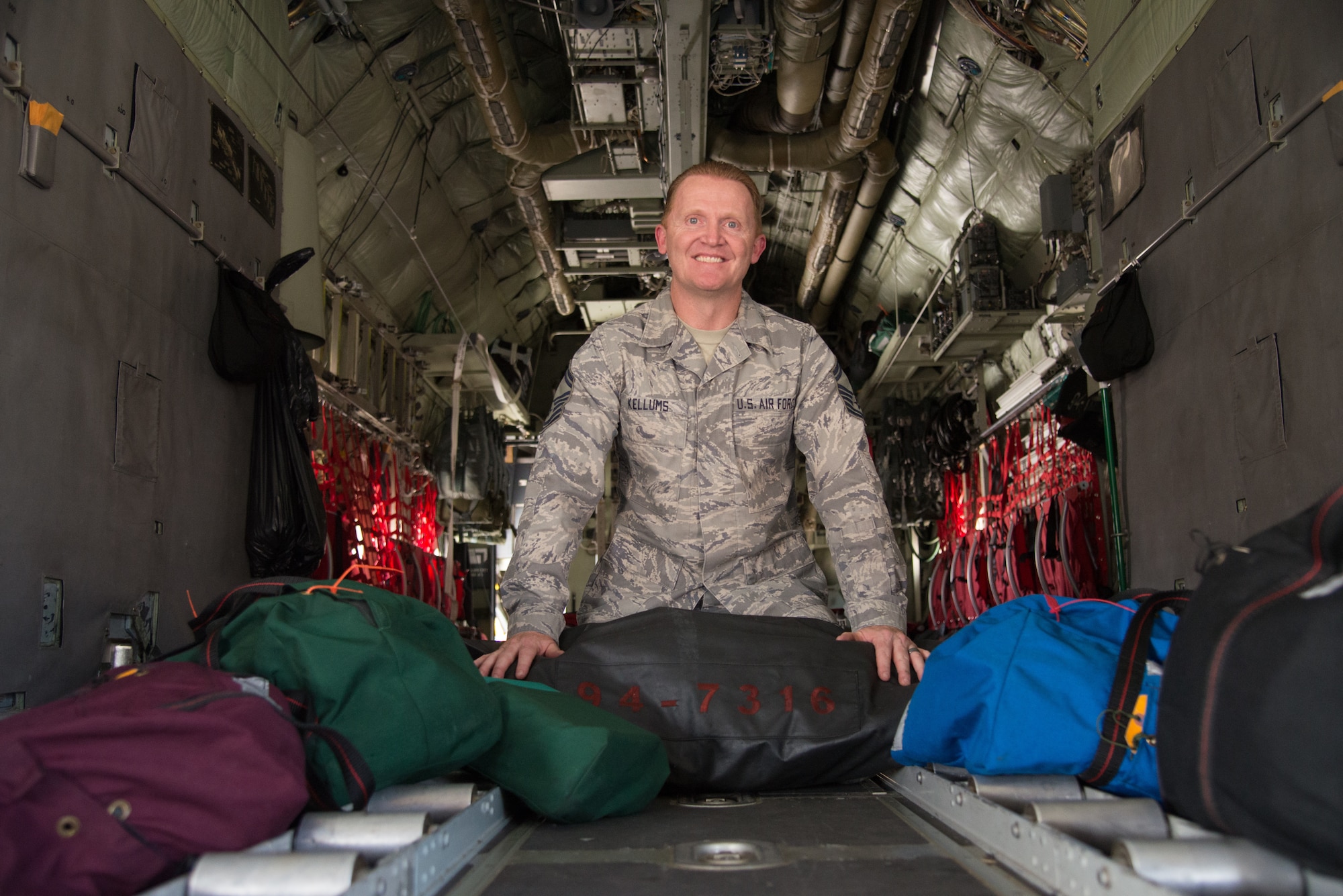 Senior Master Sgt. William Kellums, the 302nd Operations Support Squadron aircrew flight equipment superintendent, sits aboard a parked C-130 Hercules aircraft with custom-made equipment bags at Peterson Air Force Base, Colorado, Aug. 15, 2018.