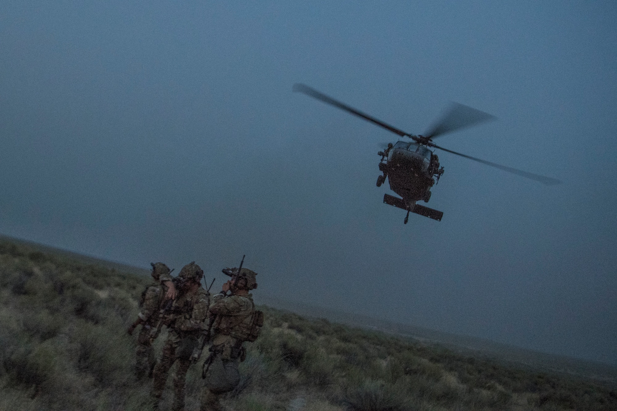 An HH-60G Pave Hawk helicopter flies above Special Tactics Airmen with the 17th Special Tactics Squadron during Jaded Thunder at Mountain Home Air Force Base, Idaho, Aug. 20, 2018.