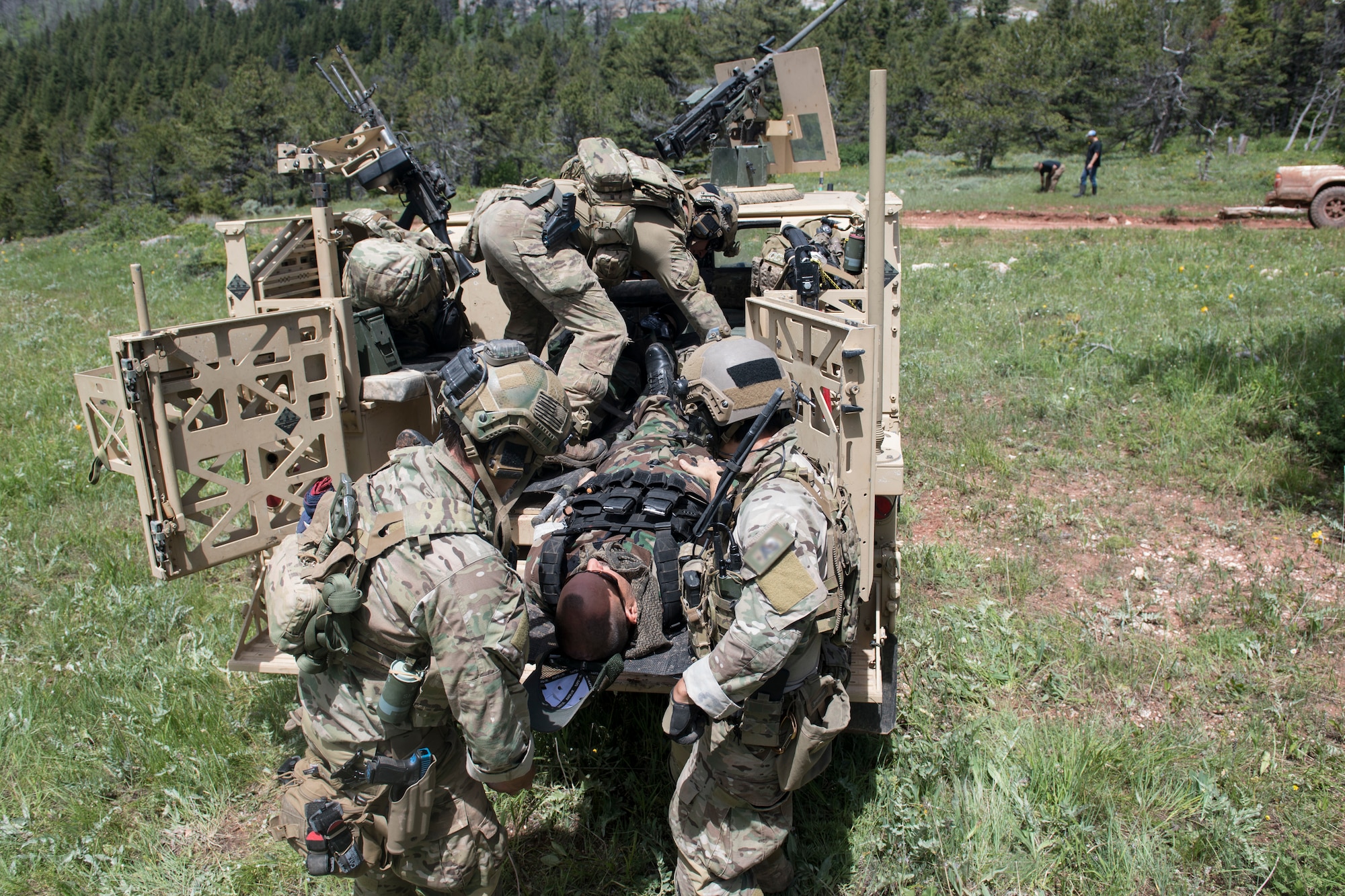 Special Tactics Airmen with the 26th Special Tactics Squadron load a simulated patient onto a vehicle at Crow Indian Reservation, Montana, June 19, 2018.