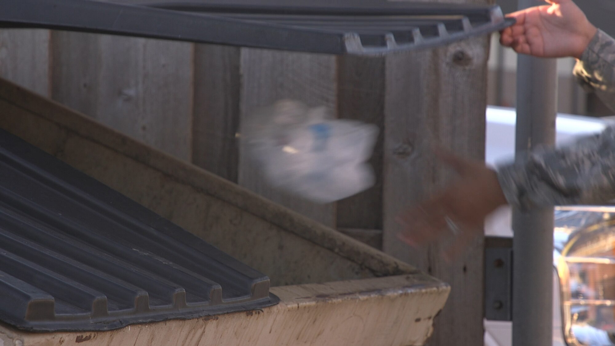 A U.S. Air Force Airman assigned to the 97th Air Mobility Wing throws away trash from the base clean-up, Sep. 20, 2018 at Altus Air Force Base, Okla. Base clean-ups require teamwork and participation from the majority of base personnel. (U.S. Air Force Photo by Airman 1st Class Dylan Murakami)