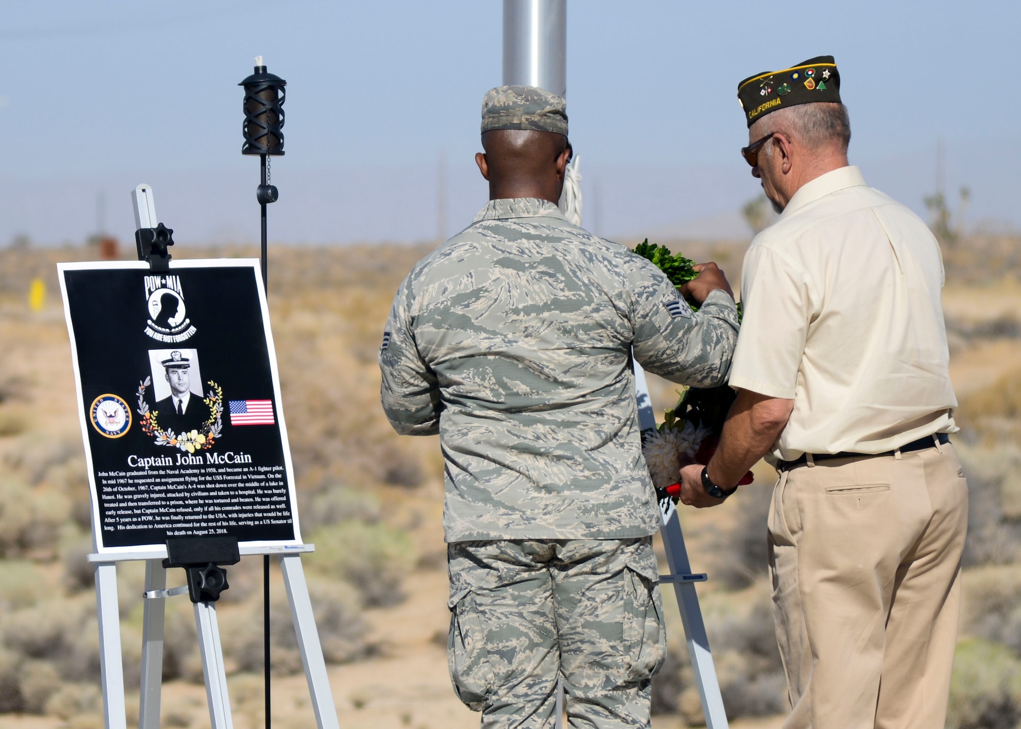 Staff Sgt. Matthew Buckner, 412th Training Wing Staff Judge Advocate’s Office, and Army Veteran Joseph Antone, a member of the Veterans of Foreign Wars Post 9657, lay a wreath next to a photo of the late Sen. John McCain during a wreath-laying ceremony commemorating National POW/MIA Recognition Day at the Airman Leadership School Drill Pad at Edwards Air Force Base, California, Sept. 21. Prior to serving as U.S. Senate member, McCain served as a Navy pilot when he was shot down over Hanoi, Vietnam and held as a prisoner of war for more than five years. (U.S. Air Force photo by Giancarlo Casem)