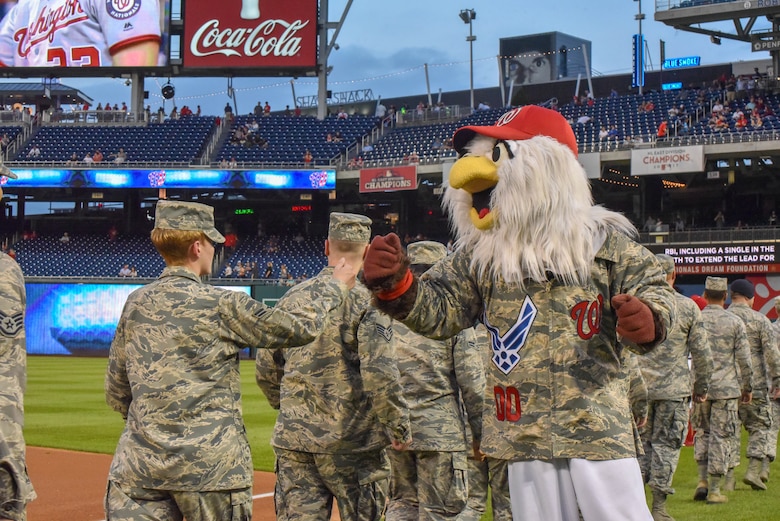 A mascot fist bumps an Airman.