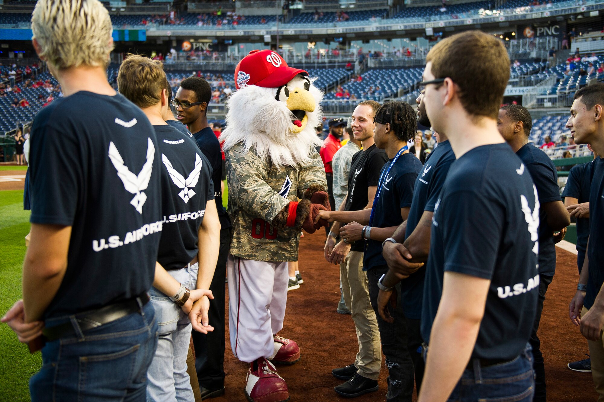 A mascot shakes hands with Airmen.