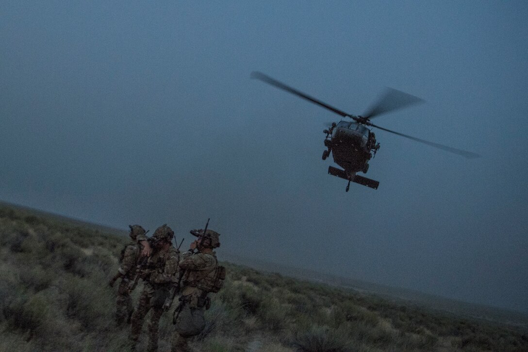 An HH-60G Pave Hawk helicopter flies above Special Tactics Airmen with the 17th Special Tactics Squadron during Jaded Thunder at Mountain Home Air Force Base, Idaho, Aug. 20, 2018.