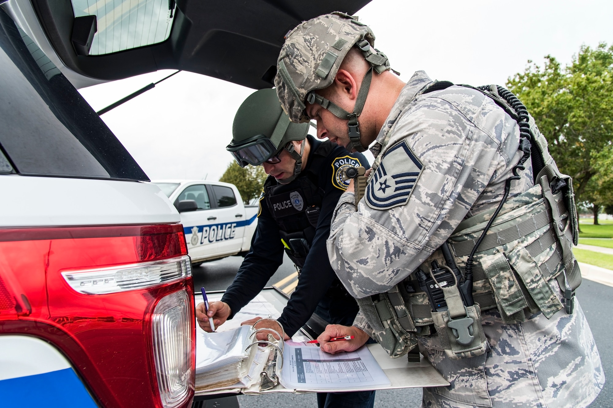 Justin Viens, supervisory police officer, and Master Sgt. Michael Kohne, flight chief, both assigned to the 436th Security Forces Squadron, go through an incident checklist to set up a cordon Sept. 17, 2018, on Dover Air Force Base, Del. Viens and Kohne coordinated efforts to secure the area around the base’s centralized mail handling facility where a mock unknown substance had leaked from a package inside the mailroom. This scenario was part of the base-wide Force Protection/Major Accident Response Exercise. (U.S. Air Force photo by Roland Balik)