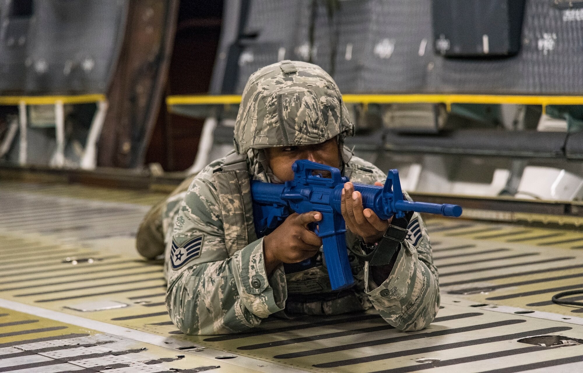 Staff Sgt. Allen Riley, 436th Security Forces Squadron response force leader, takes a prone position on the floor of a C-5M Super Galaxy cargo compartment after entering the aircraft from a rear door Sept. 17, 2018, on Dover Air Force Base, Del. Riley and other response force members located and neutralized the mock hijacker who was holding mock hostages in the aircraft’s troop compartment. (U.S. Air Force photo by Roland Balik)