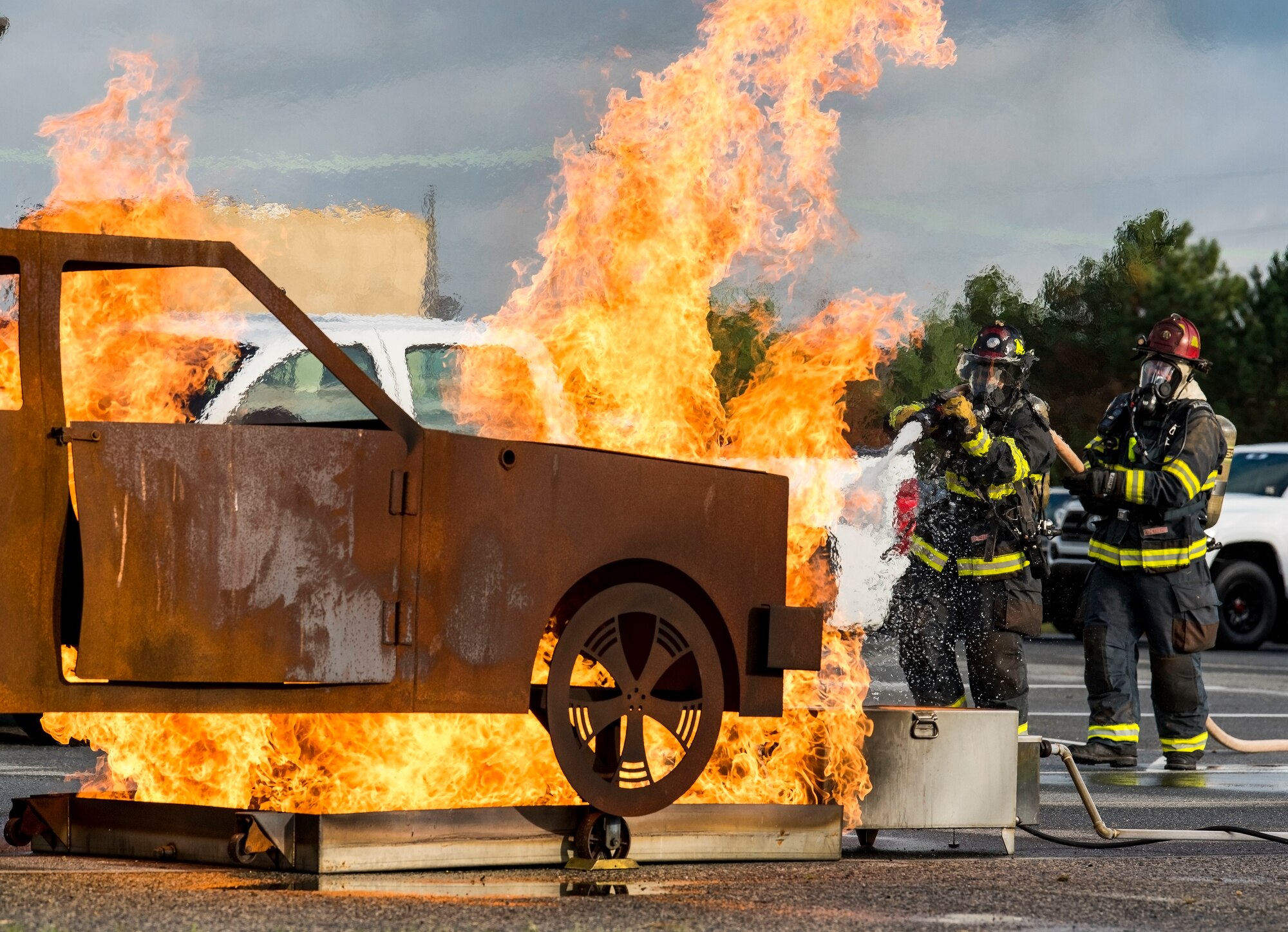 Senior Airman Hakeim McKenzie, driver/operator, and Jeffrey McCombs, fire captain, both assigned to the 436th Civil Engineer Squadron Fire Department, get in position to extinguish a simulated vehicle fire during a Force Protection/Major Accident Response Exercise scenario Sept. 18, 2018, on Dover Air Force Base, Del. Numerous base agencies were evaluated on responding to the mock vehicle gate runner and intoxicated driver involved in a motor vehicle accident. (U.S. Air Force photo by Roland Balik)