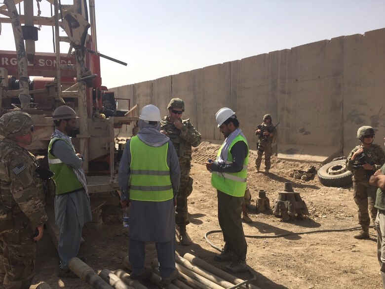 Construction Control Representative, James Fielden, Local National Quality Assurance Representative, and Project Engineer Brian Cagle USACE Afghanistan District discuss the Drilling operations of a new Water Well with the contractors at the Kandahar Air Wing Waste & Water Treatment Project.