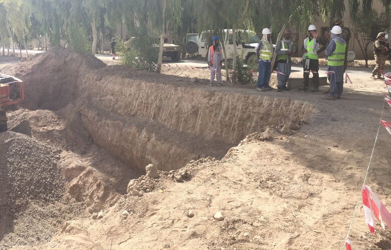 Local National Quality Assurance Representatives and Project Engineer Brian Cagle, USACE discuss the excavation of one of the new Sewage Lift Stations with the contractors at the Kandahar Waste & Water Treatment Project.