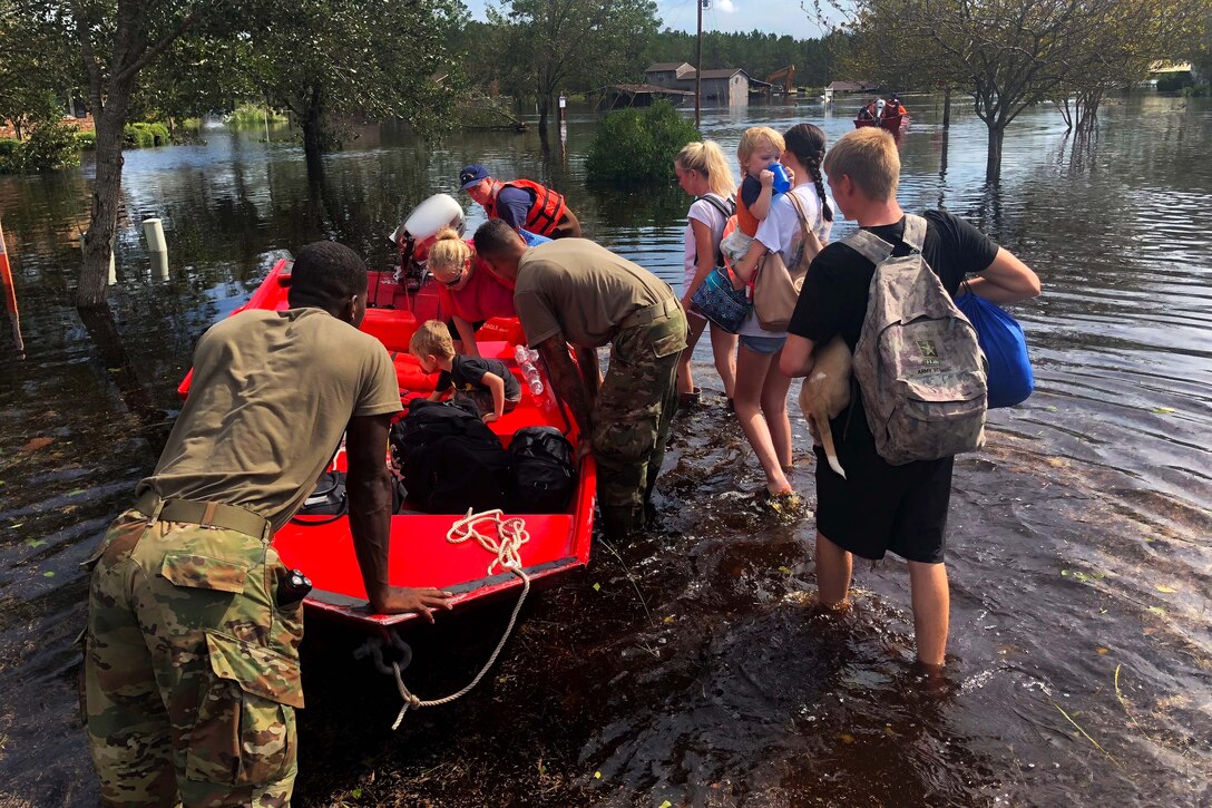 Service members help residents evacuate after flooding forced them from their homes.