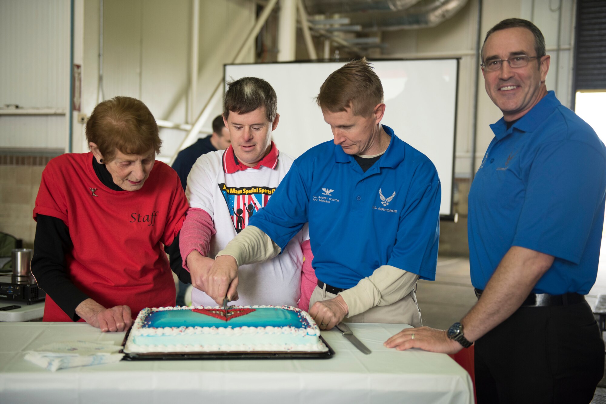From left to right, Iris Weimer, volunteer; Neil Draper, athlete; U.S. Air Force Col. Robert Horton, 352nd Special Operations Wing vice commander; and U.S. Air Force Chief Master Sgt. Clint Grizzell, 752nd Special Operations Group chief enlisted manager; cut a cake celebrating the 37th Joan Mann Special Sports Day at RAF Mildenhall, England, Sept. 22, 2018.  The event kicked off with an opening ceremony with the lighting of the Olympic torch and closed with medal presentations. (U.S. Air Force photo by Senior Airman Lexie West)