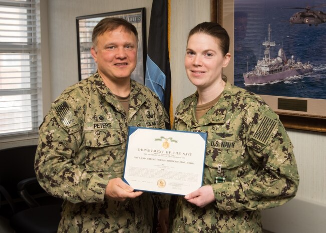 PANAMA CITY, Florida - Lt. Elizabeth Janca is awarded the Navy and Marine Corps Commendation Medal for Meritorious Service as the Airfield Manager during her tour aboard Naval Surface Warfare Center Panama City Division (NSWC PCD) by Commanding Officer Capt. Aaron Peters (left) Sept. 21, 2018. In addition, Janca received a Letter of Appreciation for her leadership, outstanding efforts and achievements as a NSWC PCD Leadership Diversity Change Agent. U.S. Navy photo by Anthony Powers