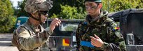 1Lt. Suwaudhaputra speaks with a Romanian Soldier at a check point during Rapid Trident 18 held at Yavoriv CTC, Ukraine, Sept. 10.