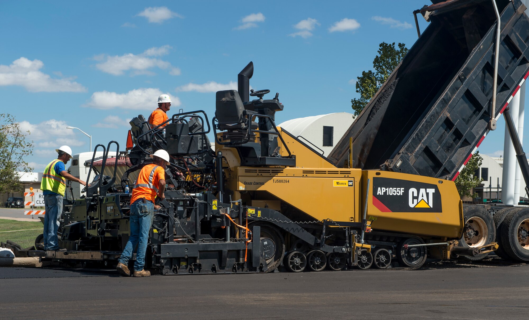 Construction contractors hired by the 97th Civil Engineer Squadron, perform the final process on paving the new roads