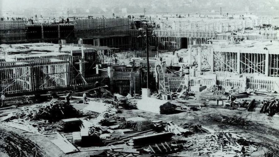 Construction debris sits in front of the beginnings of a building