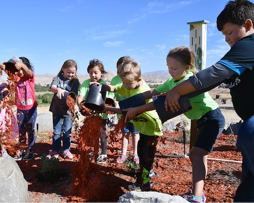 A group of young volunteers spread mulch while creating a Butterfly Garden at Success Lake during National Public Lands Day on September 22, 2018.