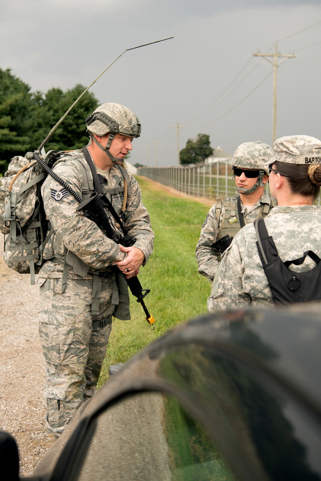 To the left, Staff Sgt. Bo Hall and Tech. Sgt. Christopher Barett, both 434th Security Forces Squadron fire team members, speak with Staff Sgt. Jessica Bartow, 316th Psychological Operations Company PSYOP specialist, during an Army Warrior Task competition at Grissom Air Reserve Base, Indiana, Sept. 21, 2018. Through the course three-member teams were required to complete nine stations designed to test combat skills. (U.S. Air Force photo by Tech. Sgt. Ben Mota)